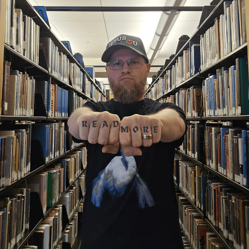Joseph VanBuren posing in a library